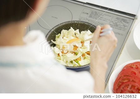 Close-up of stir-fried vegetables being fried by a woman 104126632