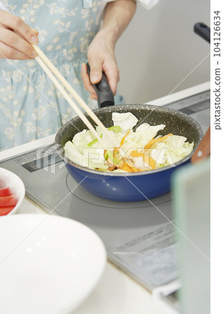 Close-up of stir-fried vegetables being fried by a woman 104126634