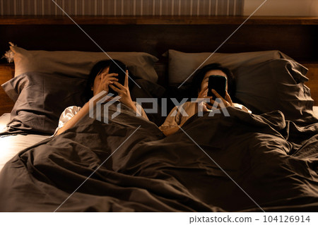 Asian female with nomophobia(No mobile phone phobia)lying on bed using smartphone in bedroom at night or symptom of Revenge Bedtime Procrastination,disease of Insomnia,mobile syndrome,social addiction Asian female with nomophobia(No mobile phone phobia)lying on bed using smartphone in bedroom at night or symptom of Revenge Bedtime Procrastination,disease of Insomnia,mobile syndrome,social addiction 104126914