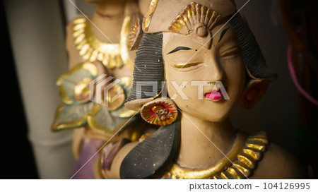 Beautiful artistic statue of a Balinese or javanese dancer used as garden decoration, javanese gnome indonesia 104126995
