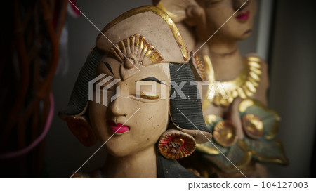 Beautiful artistic statue of a Balinese or javanese dancer used as garden decoration, javanese gnome indonesia 104127003