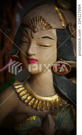 Beautiful artistic statue of a Balinese or javanese dancer used as garden decoration, javanese gnome indonesia 104127004