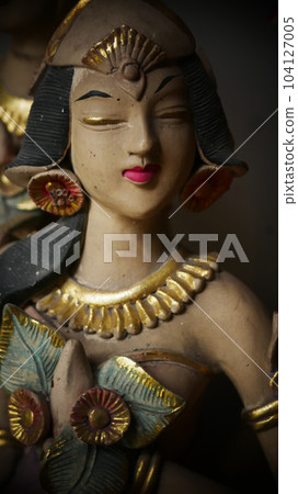 Beautiful artistic statue of a Balinese or javanese dancer used as garden decoration, javanese gnome indonesia 104127005