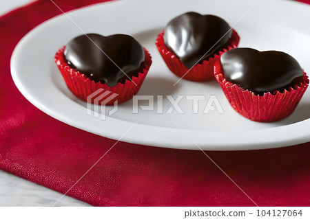 Three love shape chocolate served on the white plate. 104127064
