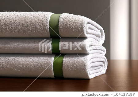 Clean three white color folded towel nice and tidy stack each other at the indoor table for fitness, bath, swimming, massage and spa marketing background and design material. Clean three white color folded towel nice and tidy stack each other at the indoor table for fitness, bath, swimming, massage and spa marketing background and design material. 104127197