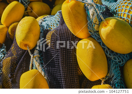 Background of colorful fishing nets with yellow floats, close-up, selective focus. Background for the concept of traditional fishing in coastal towns 104127751