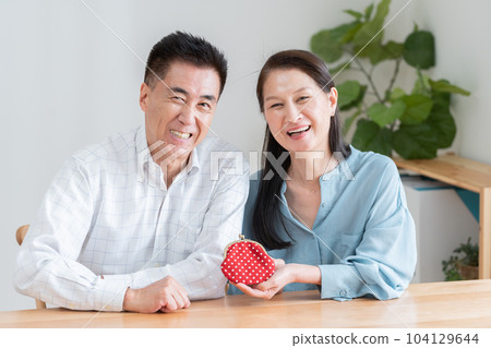 A smiling elderly couple with a purse A smiling elderly couple with a purse 104129644