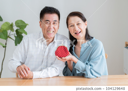 A smiling elderly couple with a purse A smiling elderly couple with a purse 104129648