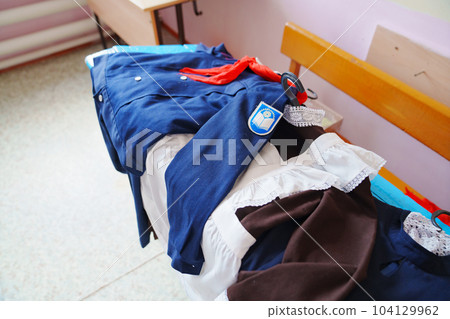 An old Soviet school uniform on a bench. An old Soviet school uniform on a bench. 104129962