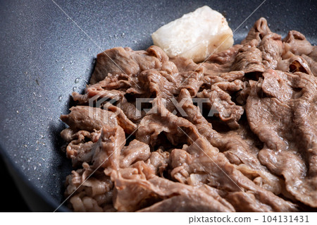 在煎鍋中烤牛肉(切成薄片)的烹飪場景。 在煎鍋中烤牛肉(切成薄片)的烹飪場景。 104131431
