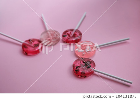 homemade fruit lollipops with pieces of fruit of different shades of pink lie in the shape of a semicircle homemade fruit lollipops with pieces of fruit of different shades of pink lie in the shape of a semicircle 104131875