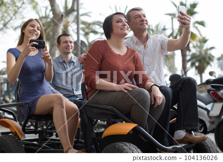 family of tourists enjoy a walk on the bike carriage 104136026