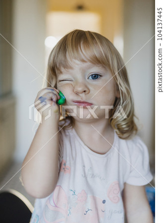 Portrait of cute little girl playing with playdough. 104137445