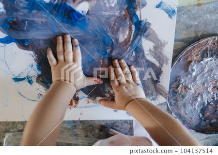 Cute little girl painting with her own hands, using tempera paint. Cute little girl painting with her own hands, using tempera paint. 104137514