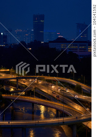 Night photo of a glowing multi-level road junction with heavy traffic. Roads in the metropolis 104141592