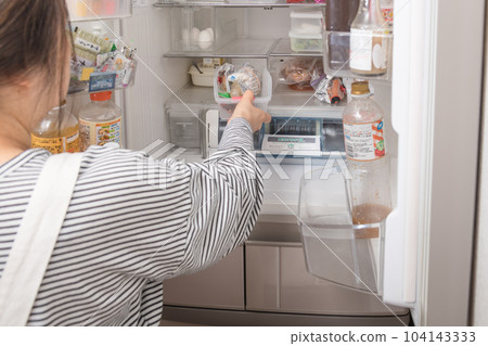 [A housewife takes out a tray from the refrigerator] 104143333