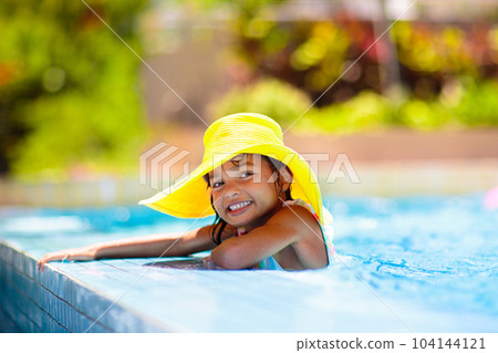 Child in swimming pool on ring toy. Kids swim. 104144121