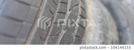 Old damaged and worn black tire thread 104144153