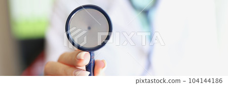 Female doctor holds stethoscope in hands closeup Female doctor holds stethoscope in hands closeup 104144186
