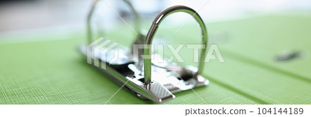 Green folder with metal clip on table Green folder with metal clip on table 104144189