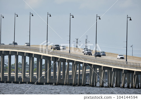 Barron Collier Bridge and Gilchrist Bridge in Florida with moving traffic. Transportation infrastructure in Charlotte County connecting Punta Gorda and Port Charlotte over Peace River 104144594