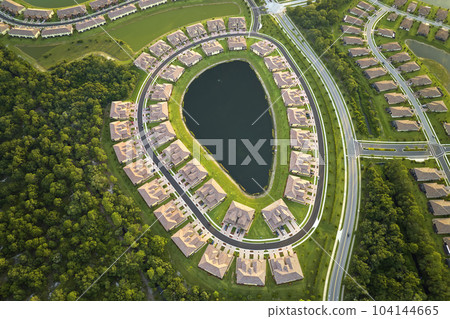 Aerial view of tightly located family houses with retention ponds to prevent flooding in Florida closed suburban area. Real estate development in american suburbs 104144665