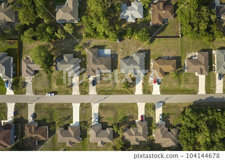 Aerial view of suburban landscape with private homes between green palm trees in Florida quiet residential area 104144678