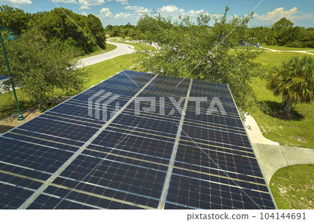 Aerial view of solar panels installed as shade roof over parking lot for parked cars for effective generation of clean electricity. Photovoltaic technology integrated in urban infrastructure 104144691