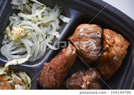 Meat appetizer with onions and cabbage. Barbecue with vegetables. Meat lunch. Meat appetizer with onions and cabbage. Barbecue with vegetables. Meat lunch. 104144790