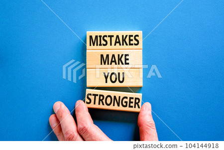 Mistake make stronger symbol. Concept words Mistakes make you stronger on wooden blocks. Beautiful blue table blue background. Businessman hand. Business mistake make stronger concept. Copy space. 104144918