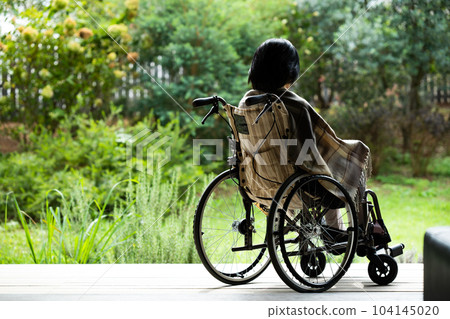 一個坐在輪椅上的女人在門廊上曬太陽 104145020