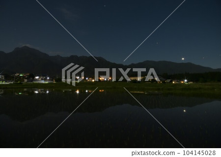 Hakushu-cho, Hokuto City, a rice field that has been planted with Venus and Mars reflected on the mountainside of the Southern Alps Hakushu-cho, Hokuto City, a rice field that has been planted with Venus and Mars reflected on the mountainside of the Southern Alps 104145028
