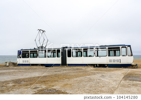 A used white electric tram car on the shore of the Baltic Sea for setting up a cafe, tram as a cafe 104145280