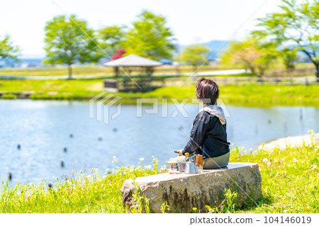 Stretching eyes on a park bench Eye muscle exercise Woman relaxing Stretching eyes on a park bench Eye muscle exercise Woman relaxing 104146019