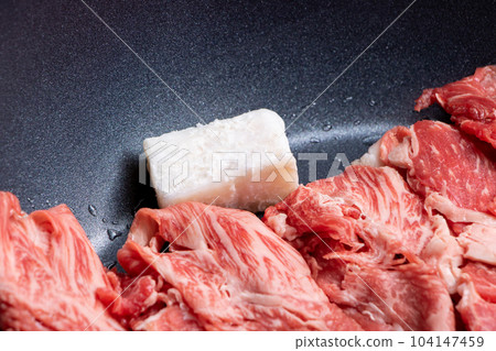 烹飪場景的特寫鏡頭，牛肉（切成薄片）在煎鍋中烤，重點是牛脂。 104147459