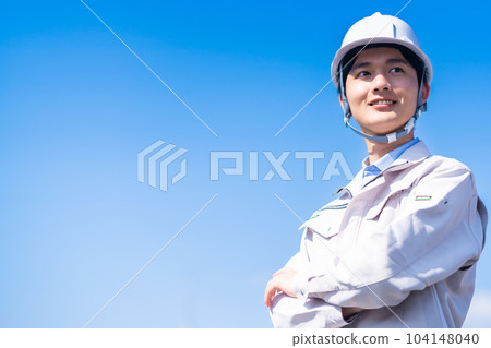 一位年輕工程師戴著頭盔站在現場 一位年輕工程師戴著頭盔站在現場 104148040