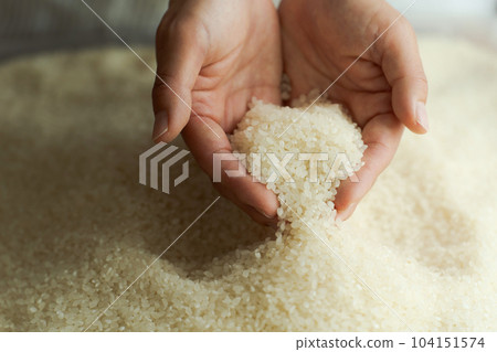 Hand photo of a woman scooping white rice Hand photo of a woman scooping white rice 104151574