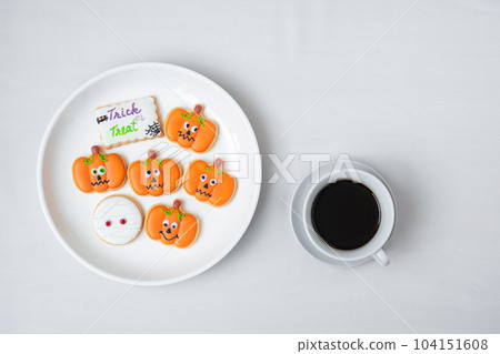 hot coffee cup with funny Halloween Cookies. Happy Halloween day, Trick or Threat, Hello October, fall autumn, Traditional, party and holiday concept hot coffee cup with funny Halloween Cookies. Happy Halloween day, Trick or Threat, Hello October, fall autumn, Traditional, party and holiday concept 104151608