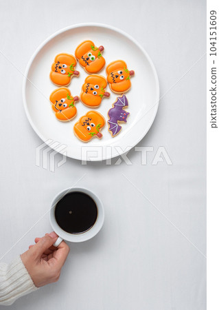 woman hand holding coffee cup during eating funny Halloween Cookies. Happy Halloween day, Trick or Threat, Hello October, fall autumn, Traditional, party and holiday concept woman hand holding coffee cup during eating funny Halloween Cookies. Happy Halloween day, Trick or Threat, Hello October, fall autumn, Traditional, party and holiday concept 104151609