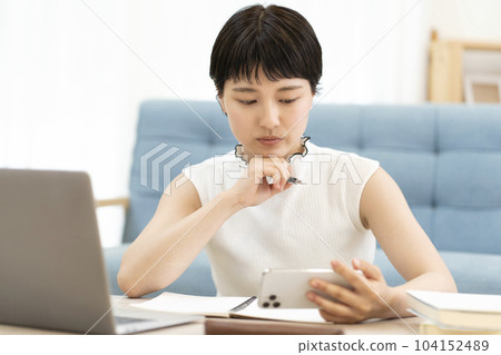A young woman studying using a smartphone, college student, high school student A young woman studying using a smartphone, college student, high school student 104152489