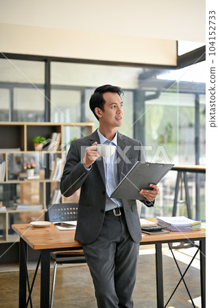 A businessman planning new strategies for his business while sipping coffee in the office. A businessman planning new strategies for his business while sipping coffee in the office. 104152733