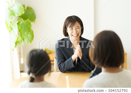 A woman in a suit having a conversation with her parent and child 104152791