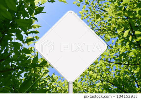 A white sign like a road sign against the background of young leaves A white sign like a road sign against the background of young leaves 104152915