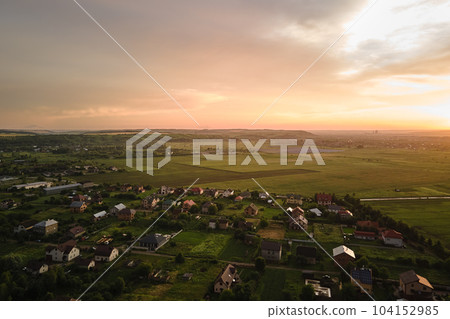 Aerial view of residential houses in suburban rural area at sunset Aerial view of residential houses in suburban rural area at sunset 104152985