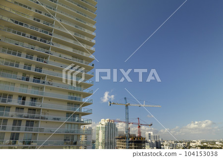 Aerial view of new developing residense in american urban area. Tower cranes at industrial construction site in Miami, Florida. Concept of housing growth in the USA 104153038