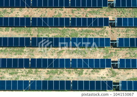 Aerial view of large sustainable electrical power plant with rows of solar photovoltaic panels for producing clean electric energy. Concept of renewable electricity with zero emission Aerial view of large sustainable electrical power plant with rows of solar photovoltaic panels for producing clean electric energy. Concept of renewable electricity with zero emission 104153067