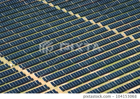 Aerial view of large sustainable electrical power plant with rows of solar photovoltaic panels for producing clean electric energy. Concept of renewable electricity with zero emission Aerial view of large sustainable electrical power plant with rows of solar photovoltaic panels for producing clean electric energy. Concept of renewable electricity with zero emission 104153068