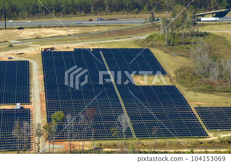 Aerial view of large sustainable electrical power plant with rows of solar photovoltaic panels for producing clean electric energy. Concept of renewable electricity with zero emission Aerial view of large sustainable electrical power plant with rows of solar photovoltaic panels for producing clean electric energy. Concept of renewable electricity with zero emission 104153069