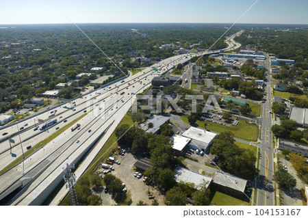 Aerial view of freeway overpass junction with fast moving traffic cars and trucks. Interstate transportation infrastructure in USA 104153167