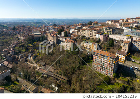 Aerial view of dense historic center of Thiers town in Puy-de-Dome department, Auvergne-Rhone-Alpes region in France. Rooftops of old buildings and narrow streets Aerial view of dense historic center of Thiers town in Puy-de-Dome department, Auvergne-Rhone-Alpes region in France. Rooftops of old buildings and narrow streets 104153239